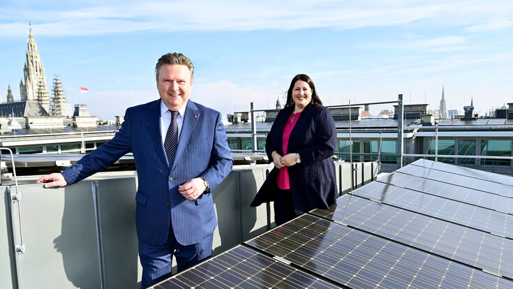 © Jobst/PID Michael Ludwig (links im Bild) und Kathrin Gaál auf einem Wiener Dach mit PV-Anlage, im Hintergrund ist das Rathaus sichtbar.