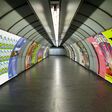 Wien: Die Plakatreihen an den Wänden setzen sich vom Grau der U-Bahnschächte ab.