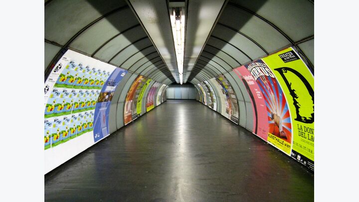 Wien: Die Plakatreihen an den Wänden setzen sich vom Grau der U-Bahnschächte ab.