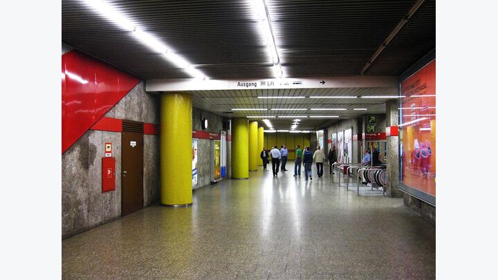 München: Gelbe Säulen treffen auf grau-rot geflieste Seitenwände.