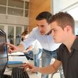Teacher and student working on computer