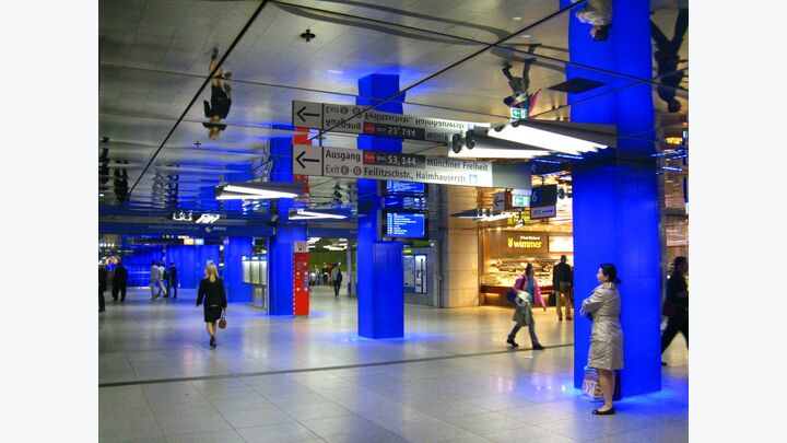 Farben können das Erscheinungsbild einzelner U-Bahnlinien oder sogar des gesamten Netzes ausmachen. In München sind die Säulen mit einer blauen Verkleidung versehen, die von innen beleuchtet wird. Die Decke wiederum ist mit Metallspiegeln ausgelegt (Abbildung 6). Durch die Spiegelungen erlebt der U-Bahngast beim Betreten dieser Halle womöglich einen kurzen Augenblick der Orientierungslosigkeit und hält inne.