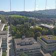 Der Blick vom Turm der Technisch-Naturwissenschaftlichen Fakultät über den Campus der JKU zeigt die unterschiedlichen Gebäudetypen. Der Hörsaaltrakt und das Keplergebäude am linken Bildrand stammen aus den 1960er-Jahren, das Bankengebäude mit Gründach aus dem Jahr 1997. Für eine Photovoltaik-Anlage wären noch viele Dachflächen frei. Alle Gebäude sind an das Wärmenetz angeschlossen. Der neue Science Park (am rechten Bildrand hinter den Bäumen) wird zudem über ein Kältenetz versorgt.
