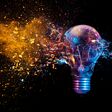 explosion of a traditional electric bulb. shot taken in high speed, at the exact moment of impact. Colored lights and black background. concept of creativity and fragility.