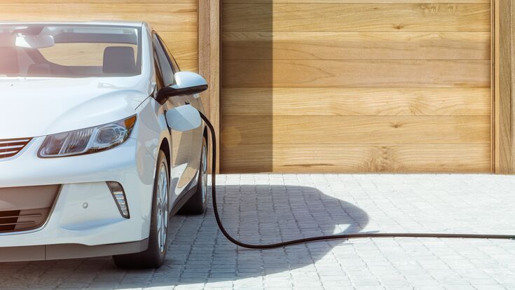 Modernes Elektroauto zu Hause Strom tanken frontal