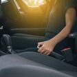 Hand woman driver pulling the hand brake inside modern car
